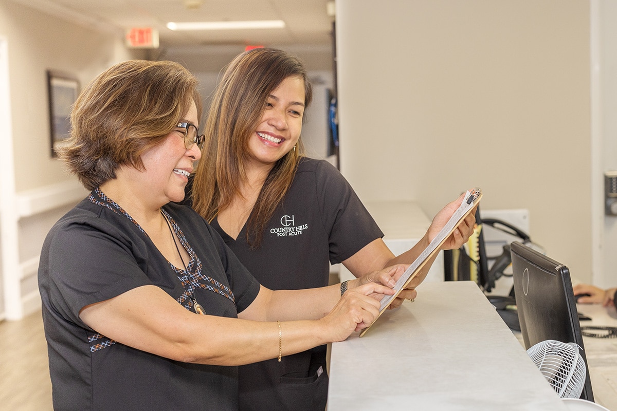 two nurses talking at the nurse's station
