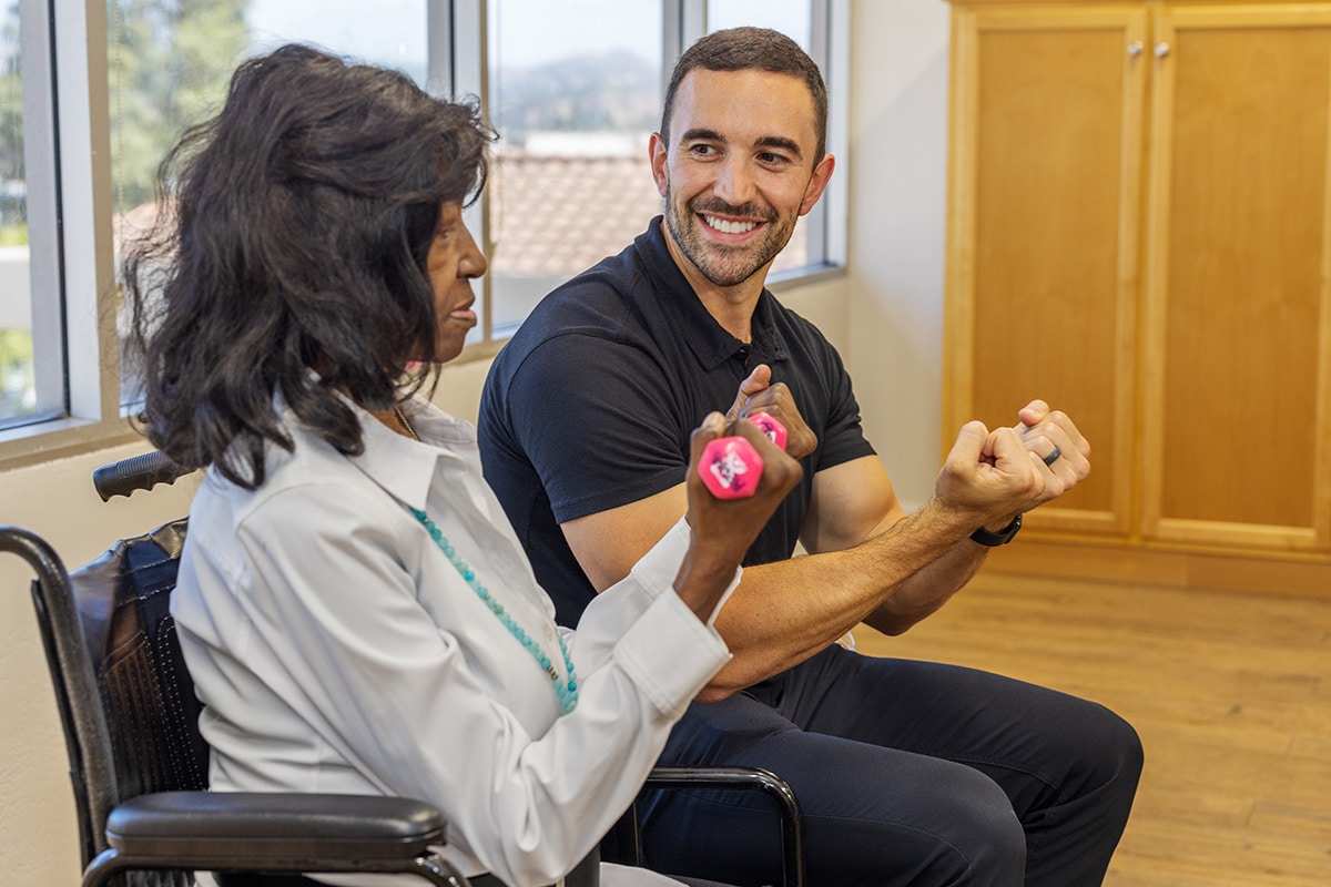 Country Hills facility rehab therapist with a resident in the rehab gym